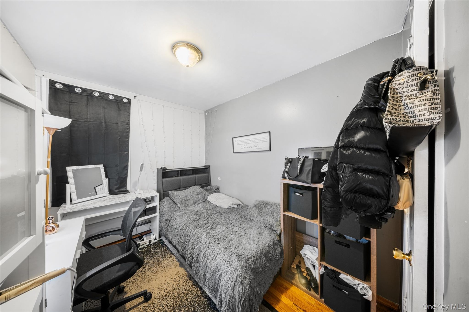 Bedroom with wood finished floors and an office area