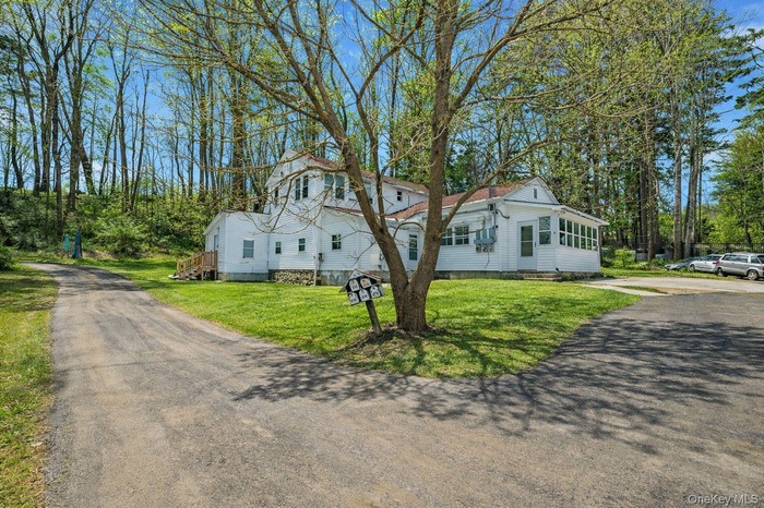 View of property exterior with a lawn and driveway