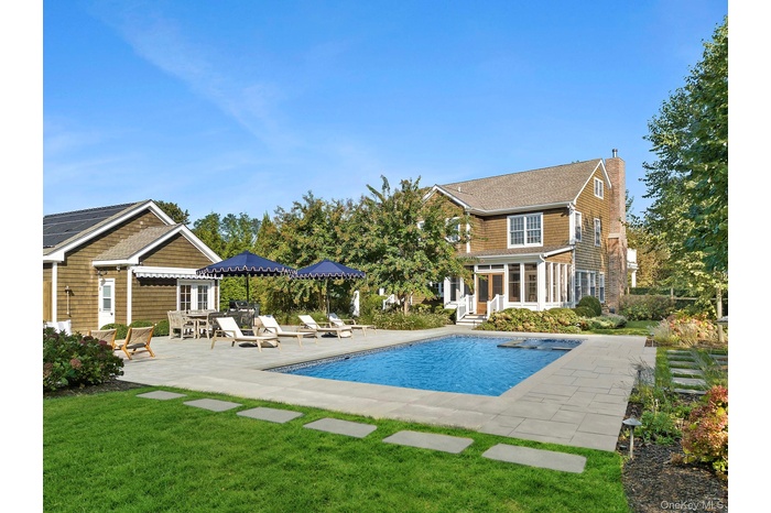 View of swimming pool, house and outbuilding.