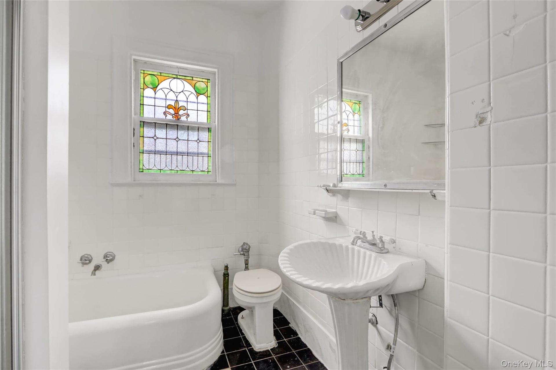 Full bathroom with a garden tub, tile walls, and dark tile patterned floors