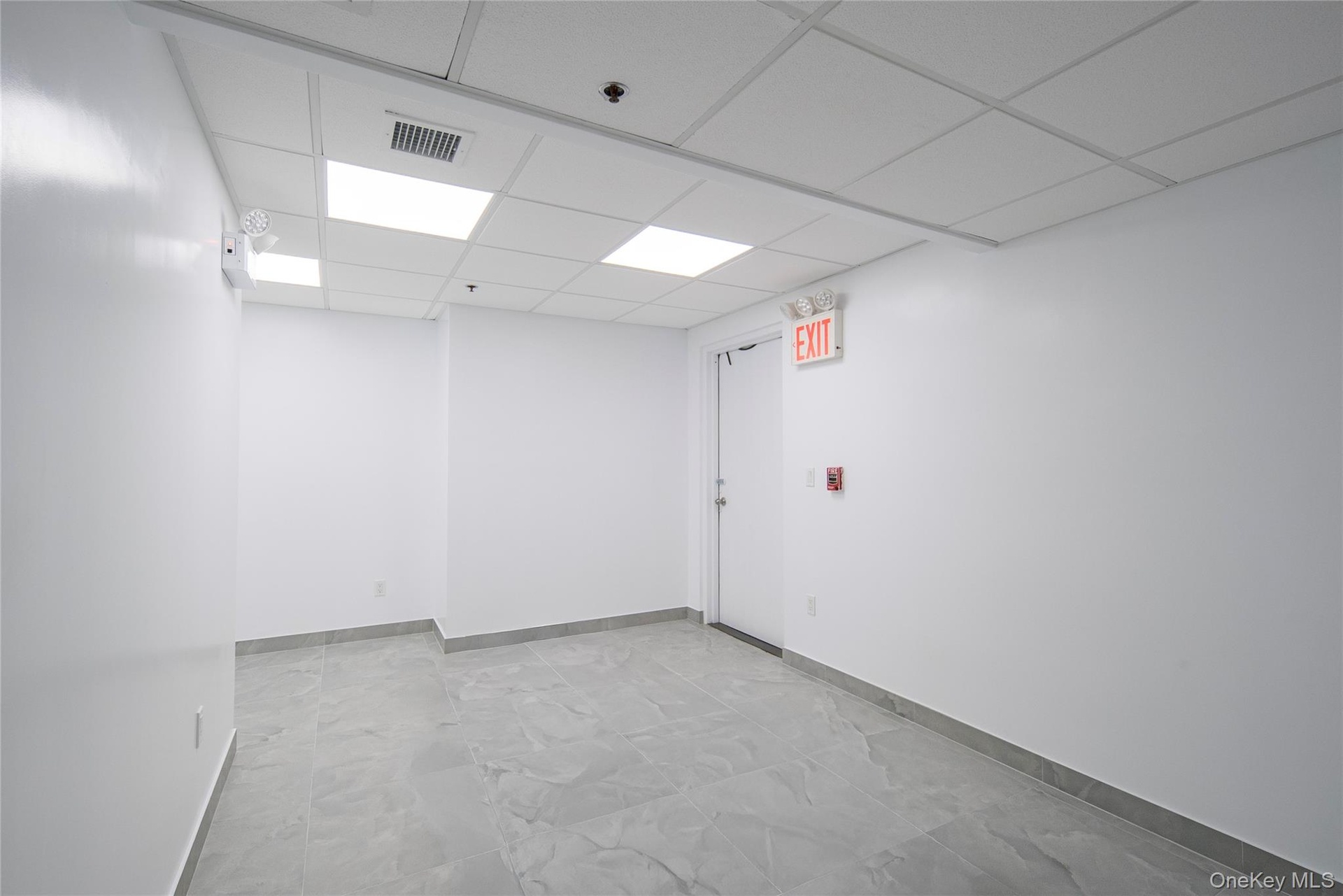 Spare room with baseboards and a paneled ceiling