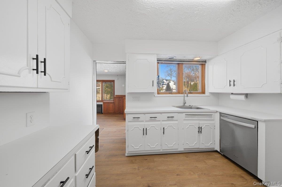 Stainless Steel appliances, New LVP flooring and modern black cabinet hardware