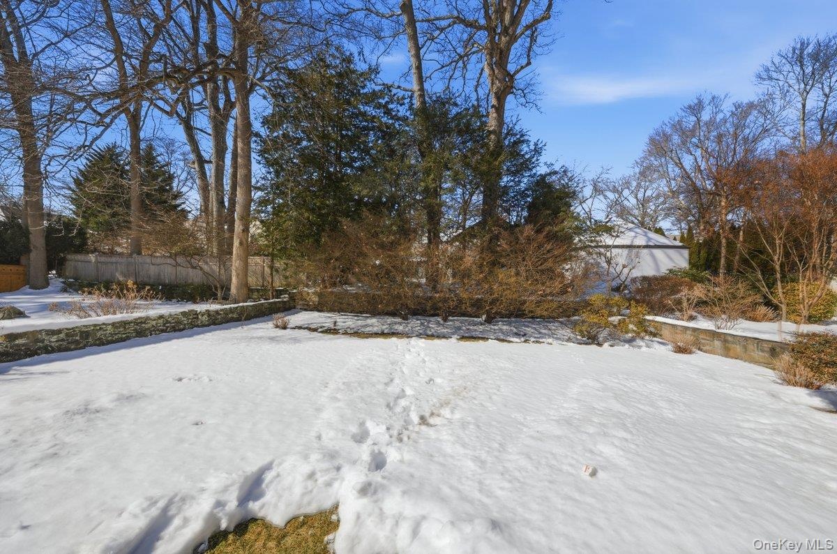 Low maintenance yard with charming stone wall and mature greenery