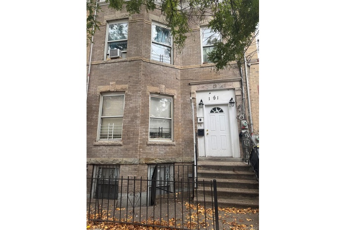View of exterior entry with brick siding and cooling unit
