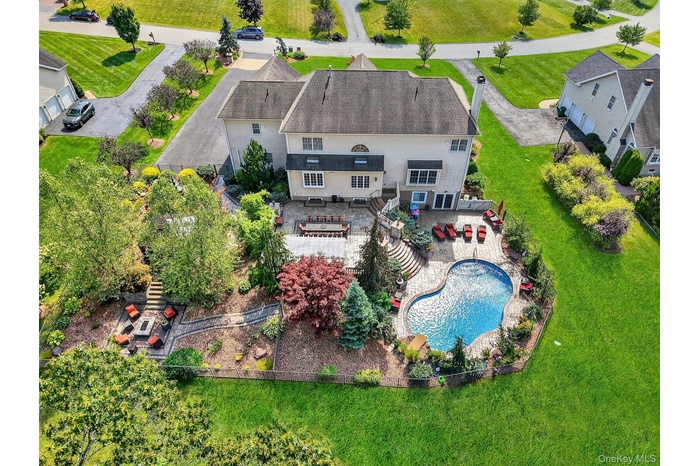 This elevated view highlights the grandeur of a meticulously landscaped backyard that blends privacy with upscale outdoor living. At the heart of the 