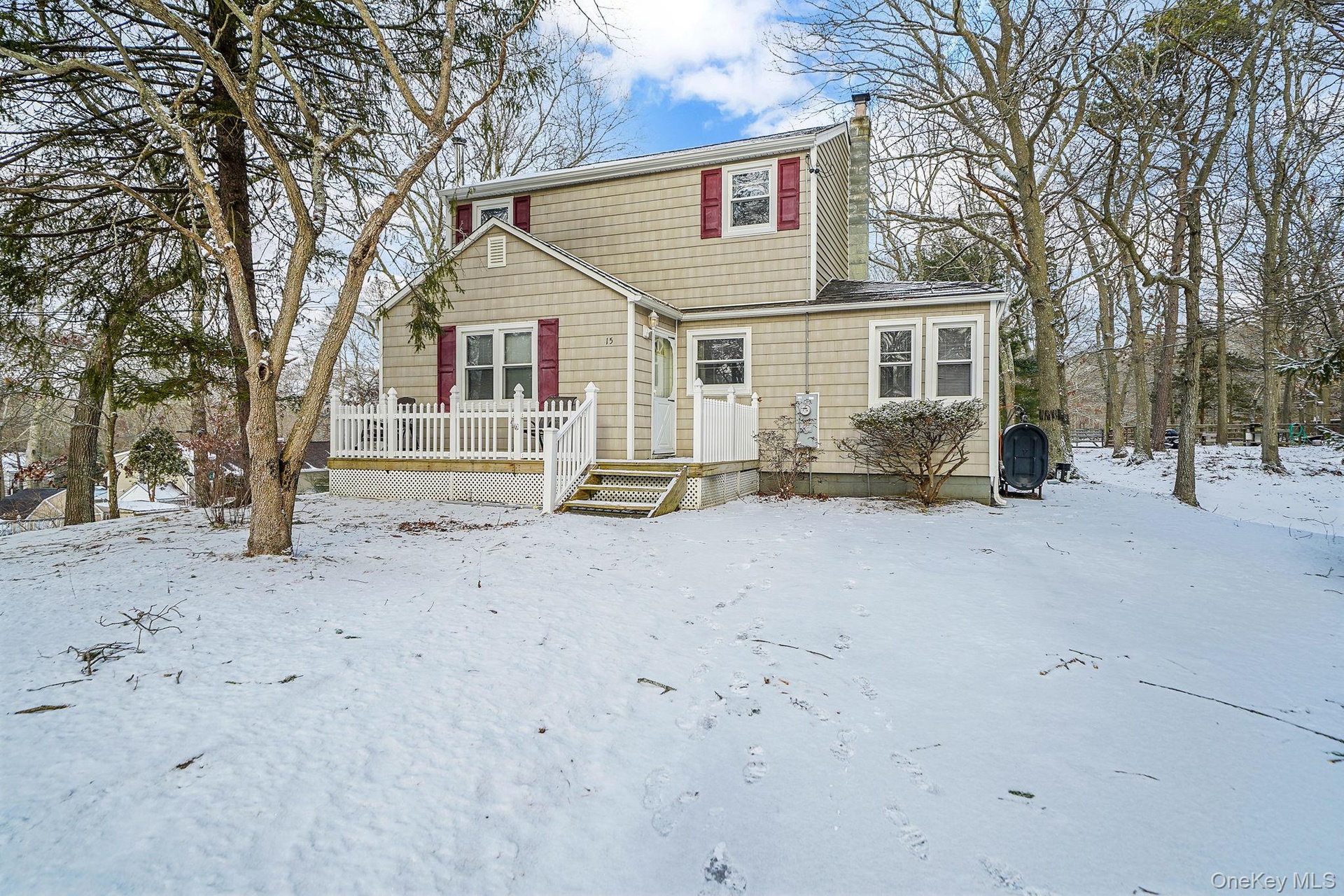 View of front of property featuring a wooden deck, a chimney, and heating fuel