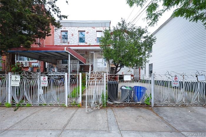 View of front of property with a fenced front yard and a gate