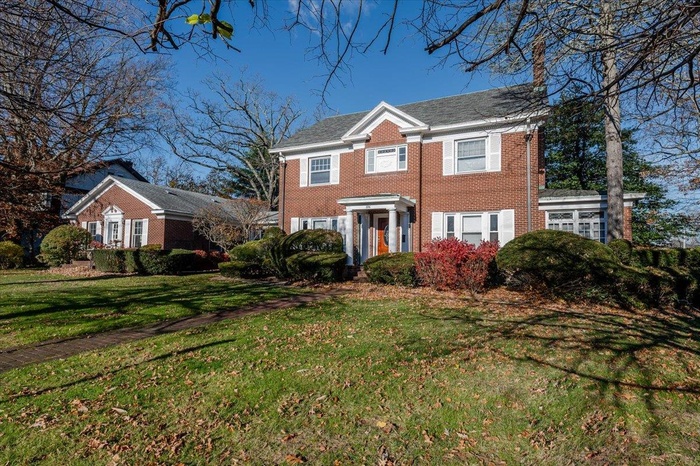 Colonial-style house featuring a front yard
