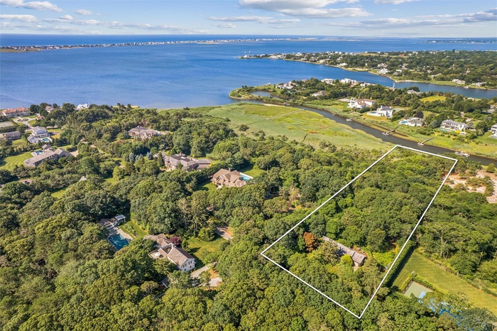 Aerial overview of property's location with a nearby body of water and property boundaries highlighted