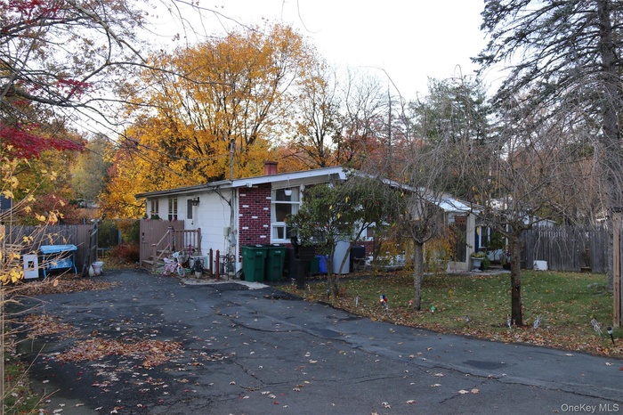 View of front of property with a chimney and asphalt driveway