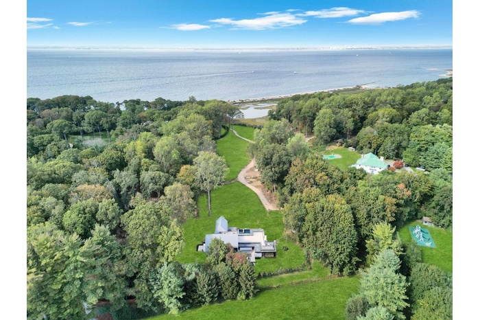 Aerial view of property and surrounding area with a nearby body of water