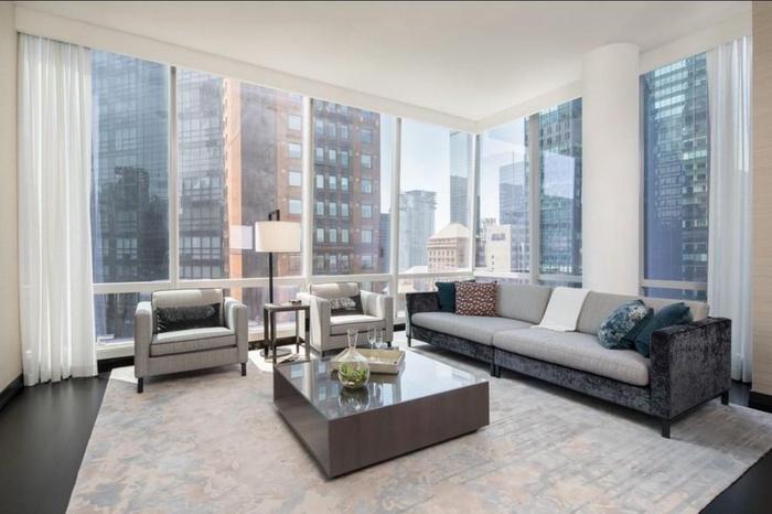 Living room with hardwood / wood-style flooring and expansive windows