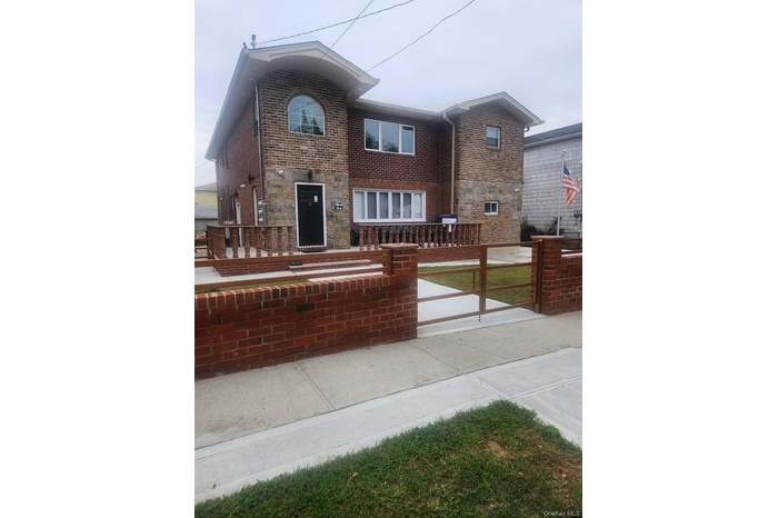 View of front facade with brick siding, stone siding, and a patio area