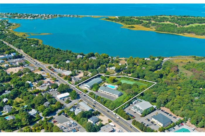 Aerial view of property and surrounding area featuring a large body of water and property parcel outlined