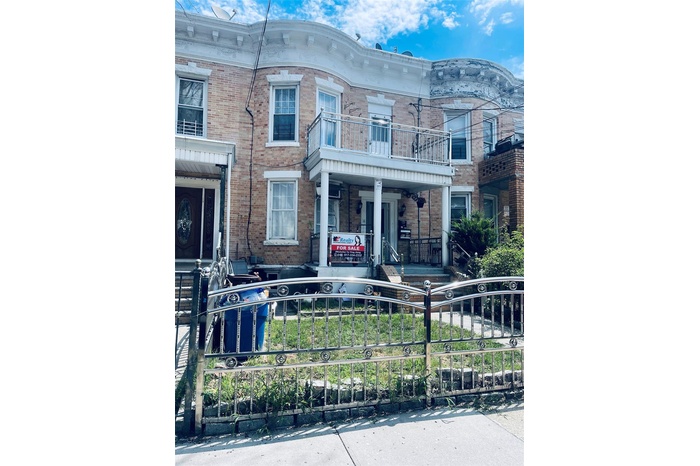 Italianate house with a fenced front yard, brick siding, and covered porch