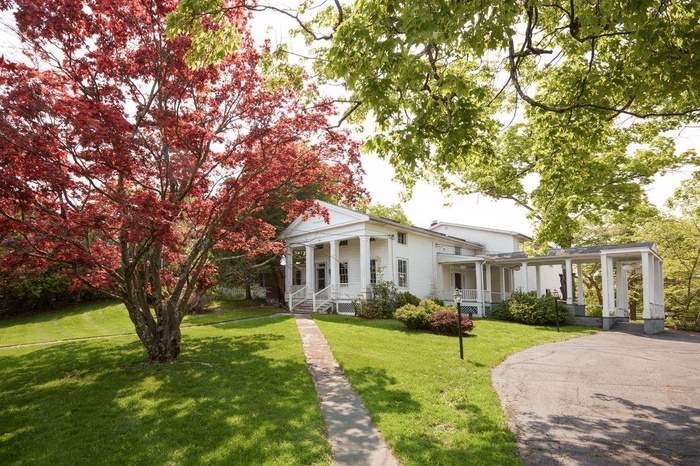 Greek revival house with covered porch and a front lawn