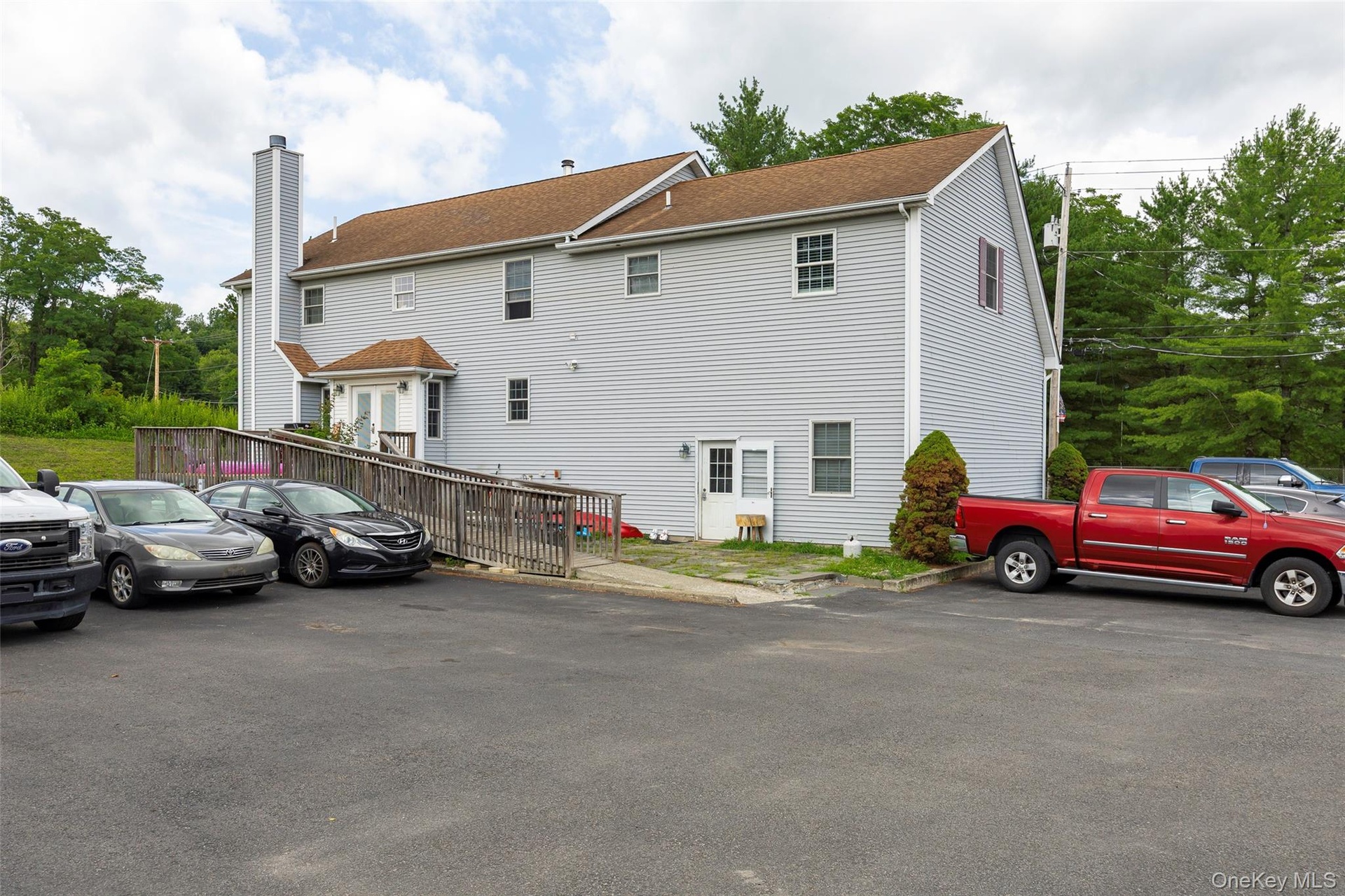Back of property with a chimney and uncovered parking