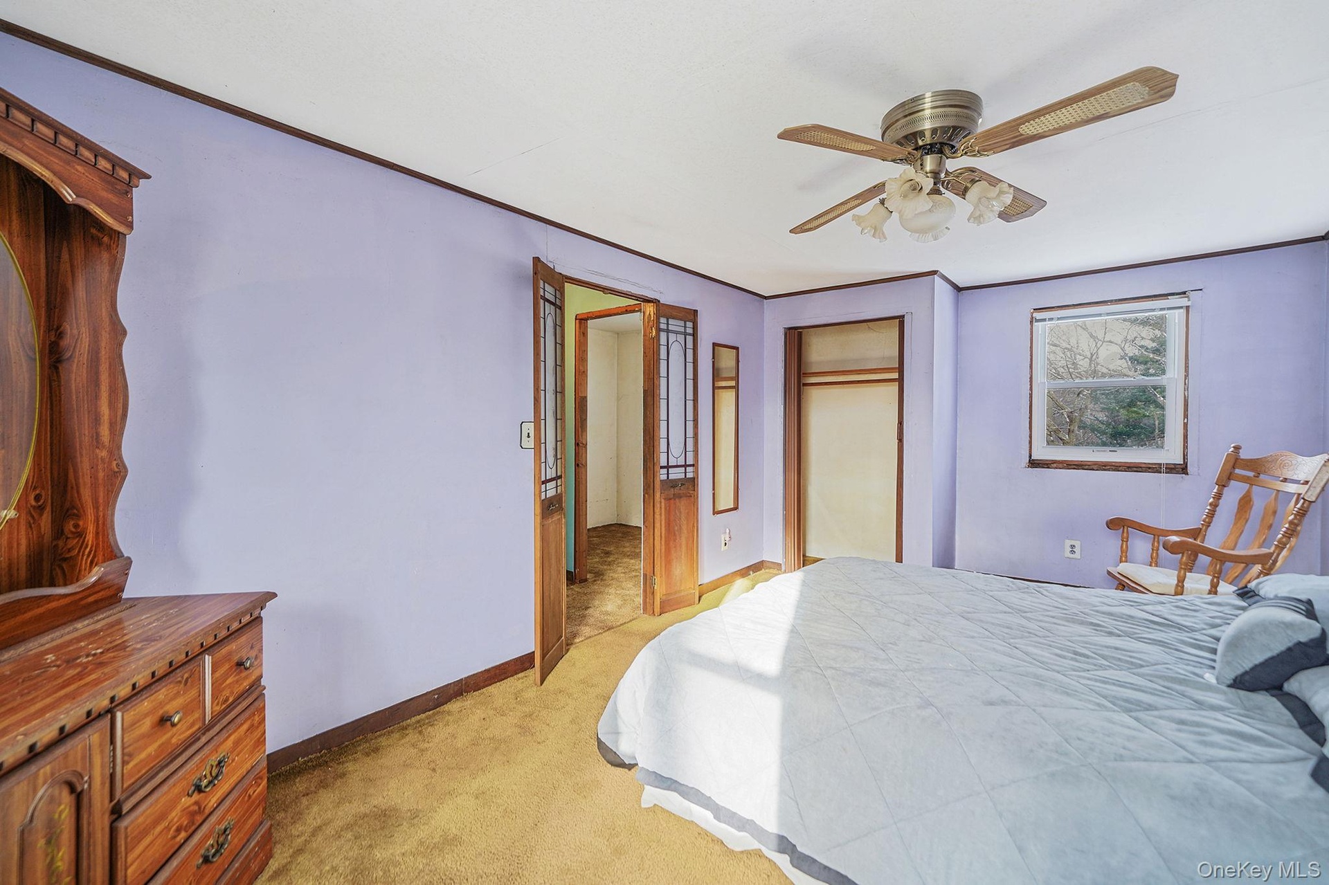 Bedroom featuring light colored carpet, a closet, ceiling fan, and ornamental molding