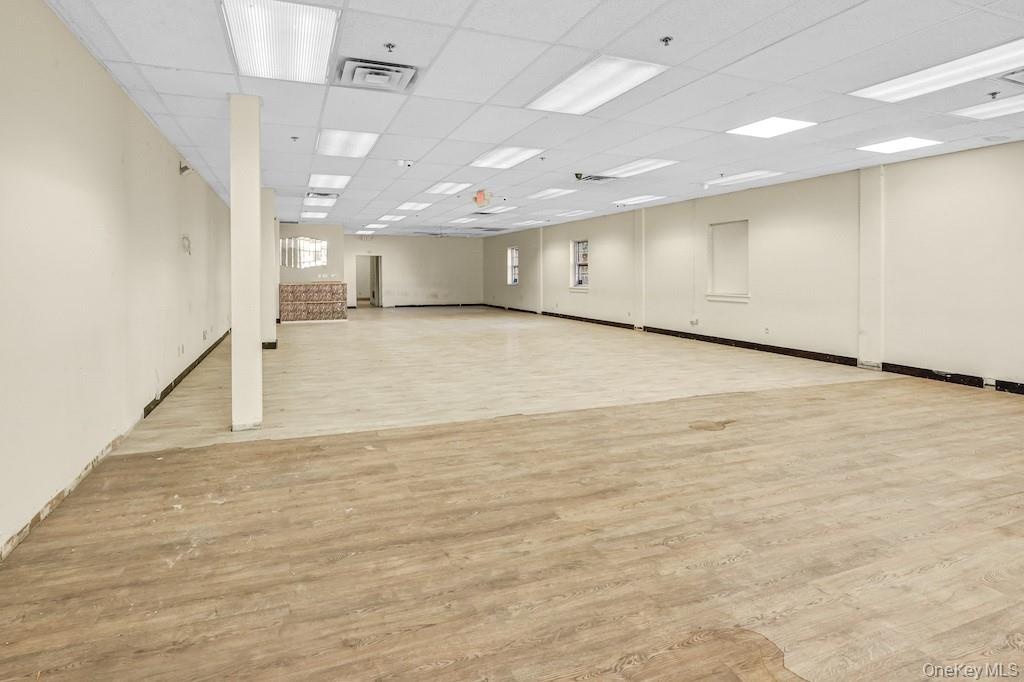 Spare room with a drop ceiling and light wood-style flooring