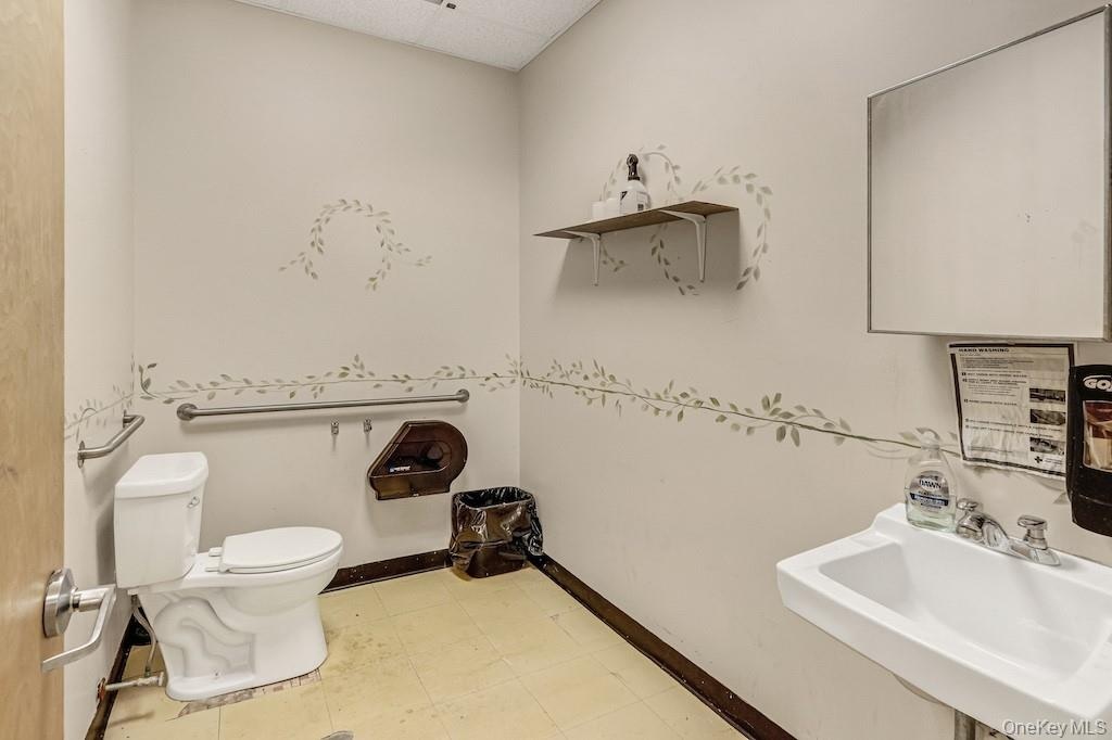 Half bathroom with light flooring and a paneled ceiling