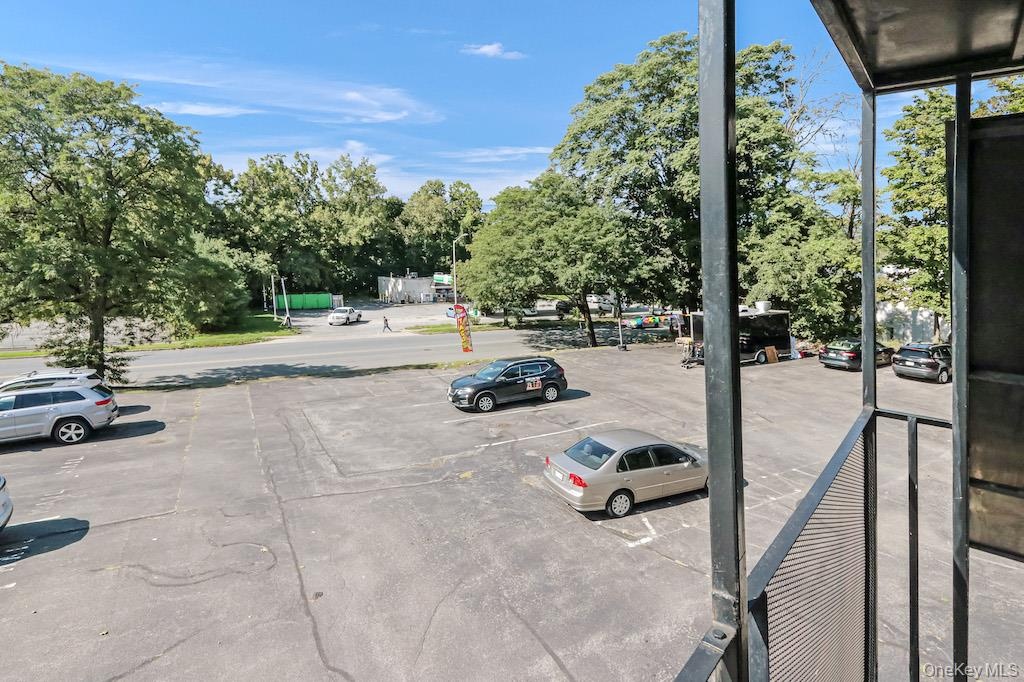 View of asphalt street with view of wooded area