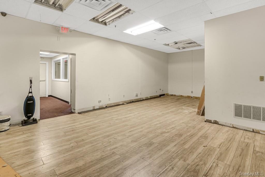 Unfurnished room featuring a paneled ceiling and light wood-style flooring
