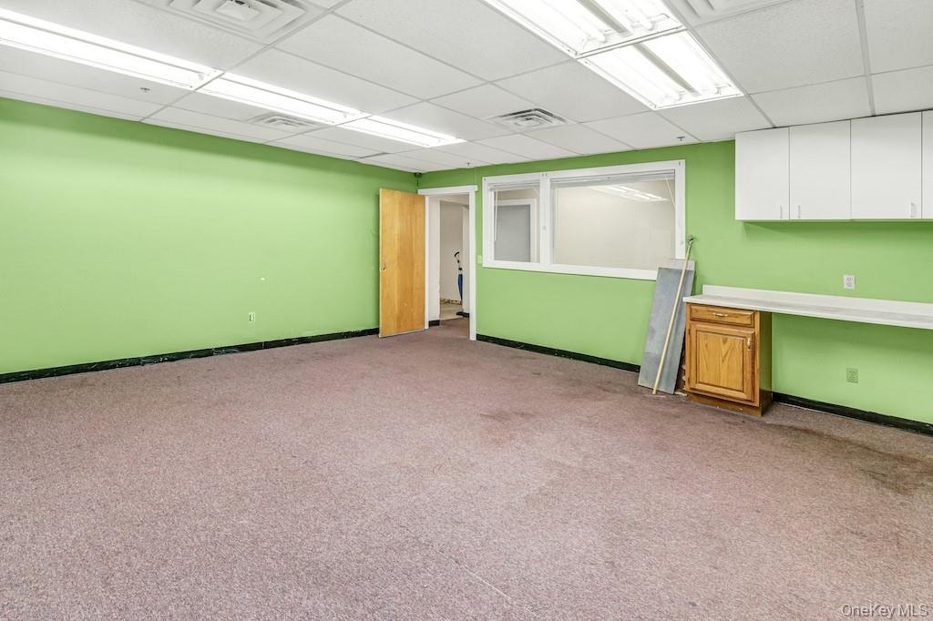 Spare room with a drop ceiling and light colored carpet