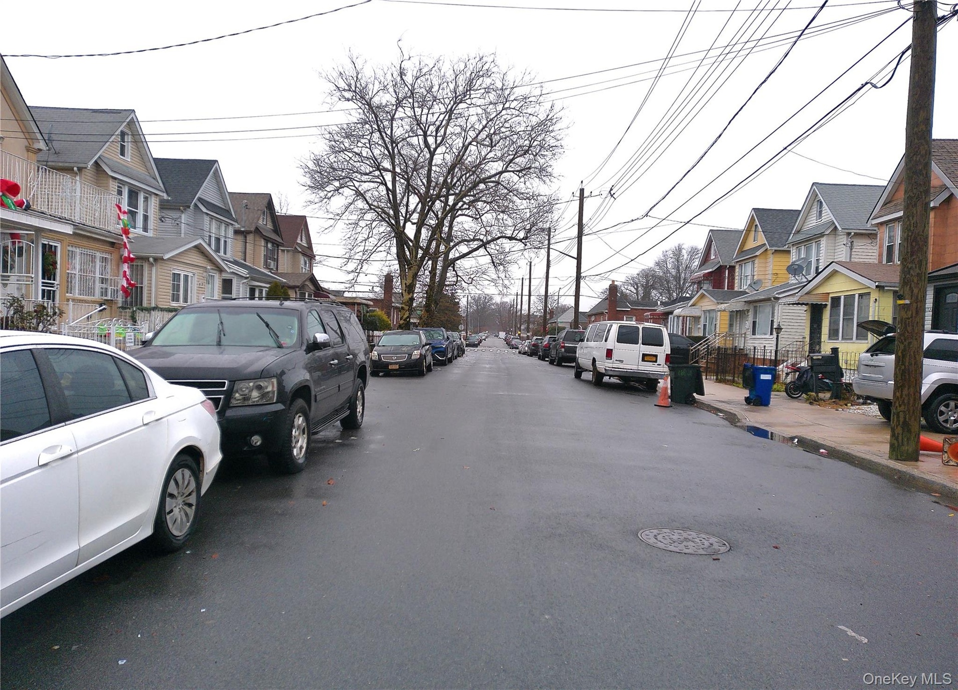 View of asphalt road with a residential view, sidewalks, and curbs