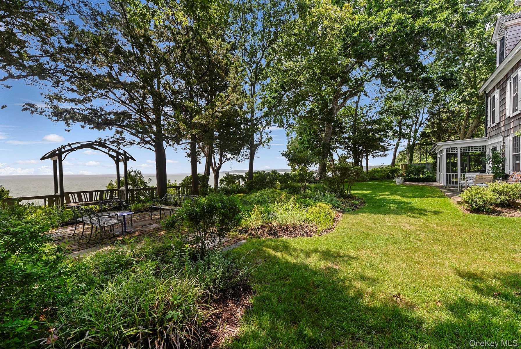 View of grassy yard featuring a water view and a patio