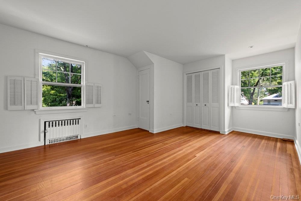 Bonus room featuring radiator heating unit and light wood-style flooring