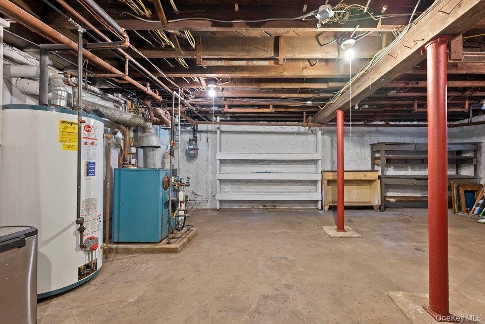 Unfinished basement featuring water heater and gas meter