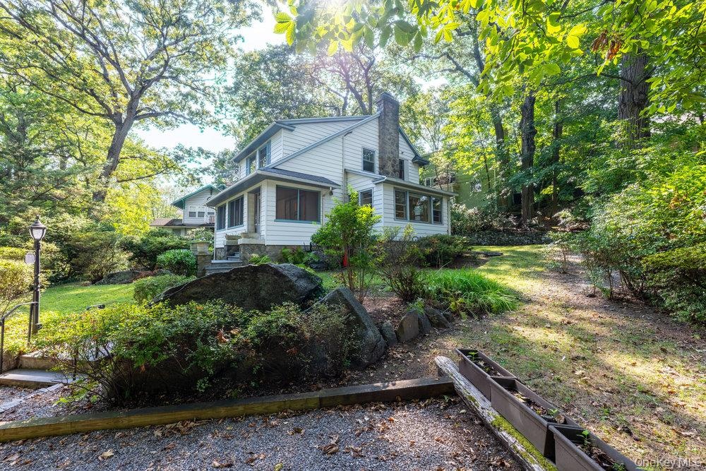 View of property exterior with a chimney and view of scattered trees