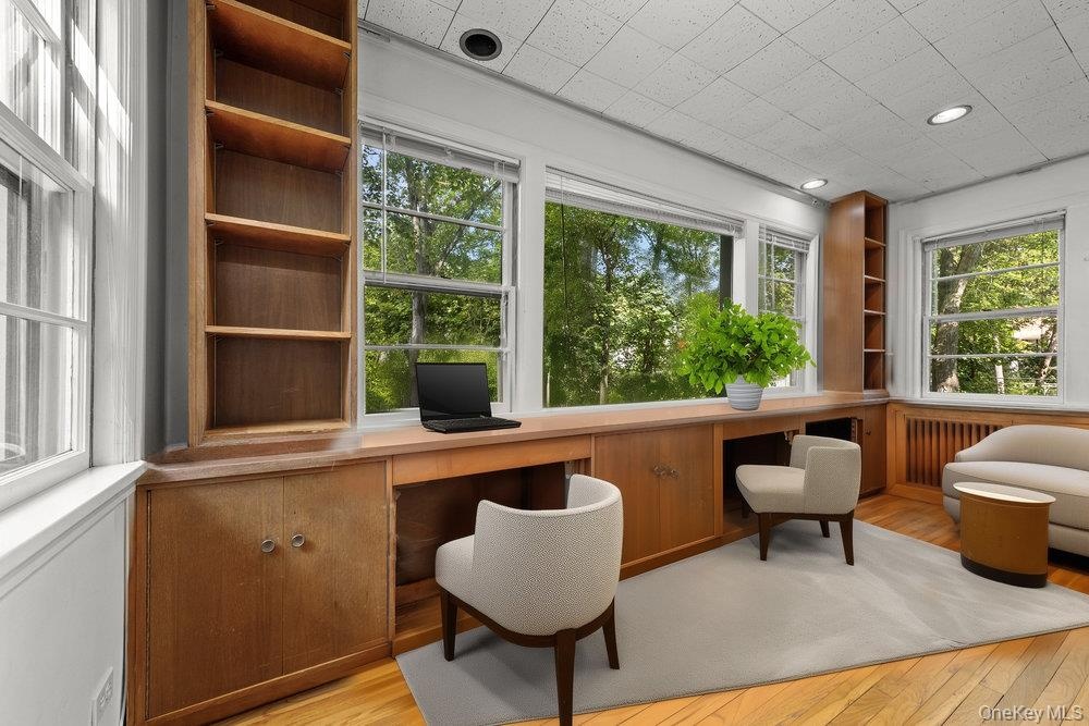 Office space featuring built in study area and light wood-style flooring