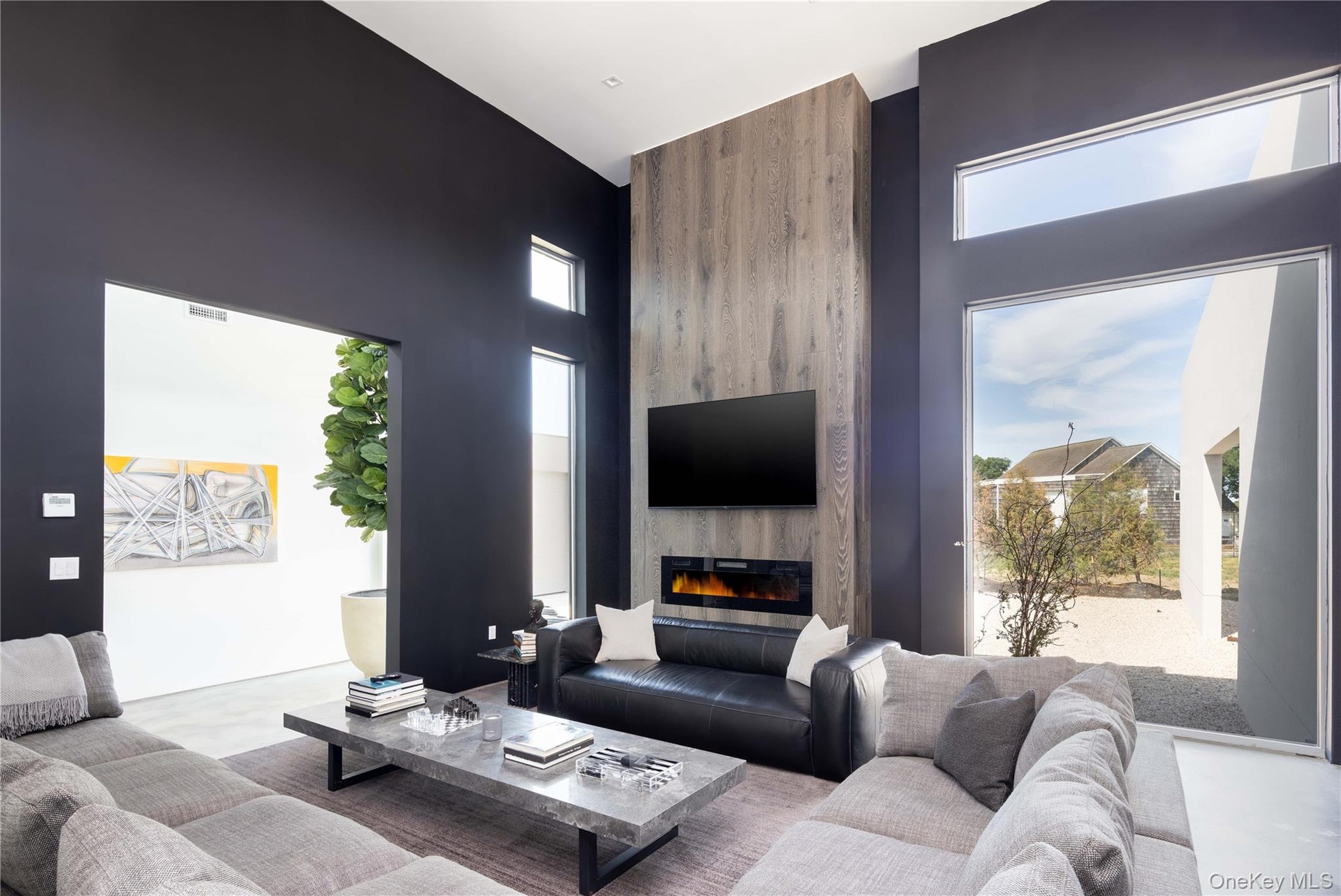 Living room featuring a towering ceiling and a fireplace