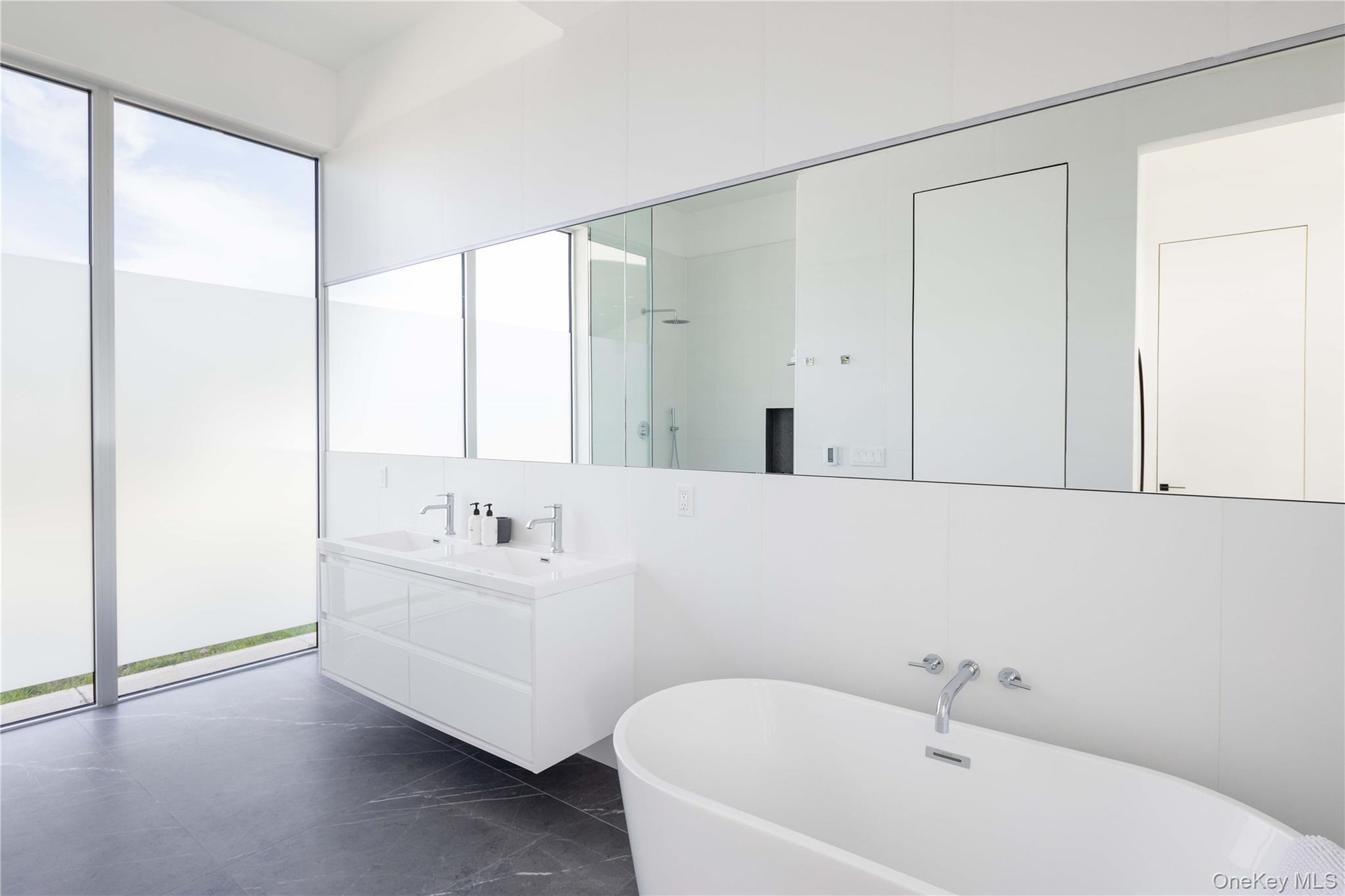Bathroom with tasteful backsplash, a washtub, and vanity