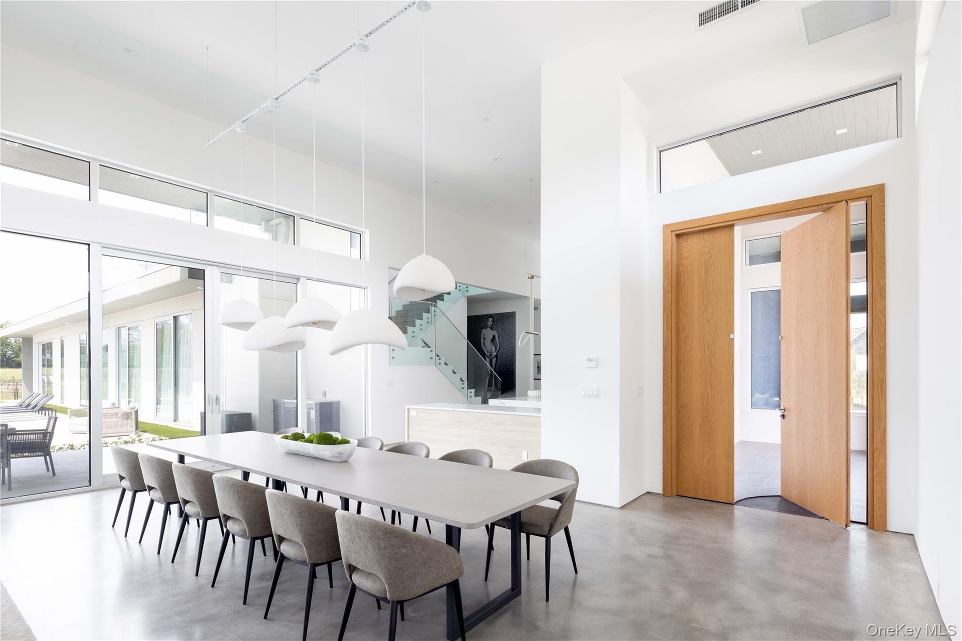 Dining area with concrete flooring, a towering ceiling, and track lighting
