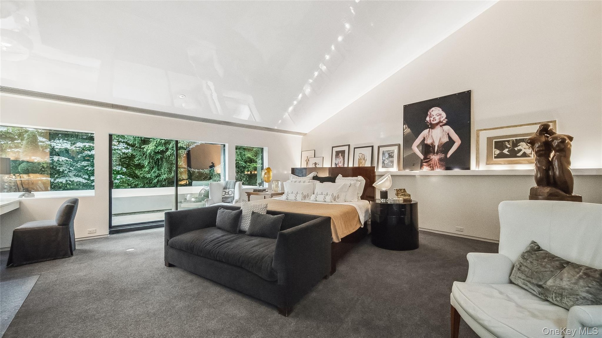 Primary Bedroom Featuring Custom Wool Carpet, High Vaulted Ceilings, and Sliders To Private Balcony