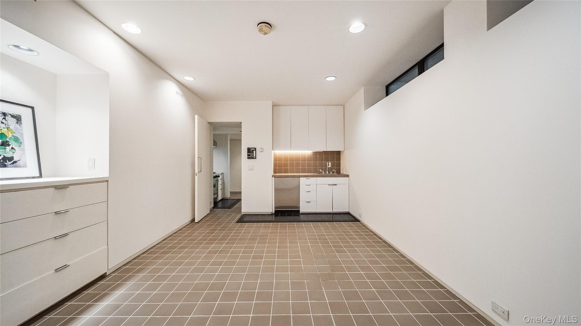Kitchen featuring white cabinets, recessed lighting, decorative backsplash, and light countertops