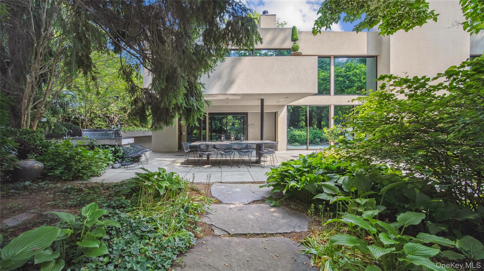 Rear view of house with stucco siding, a patio area, and a pergola