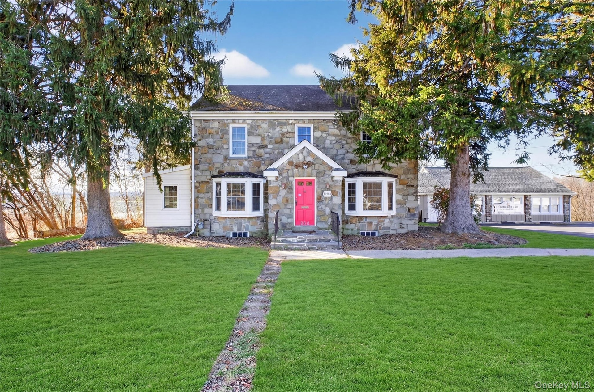 View of front of home featuring a front yard and stone siding