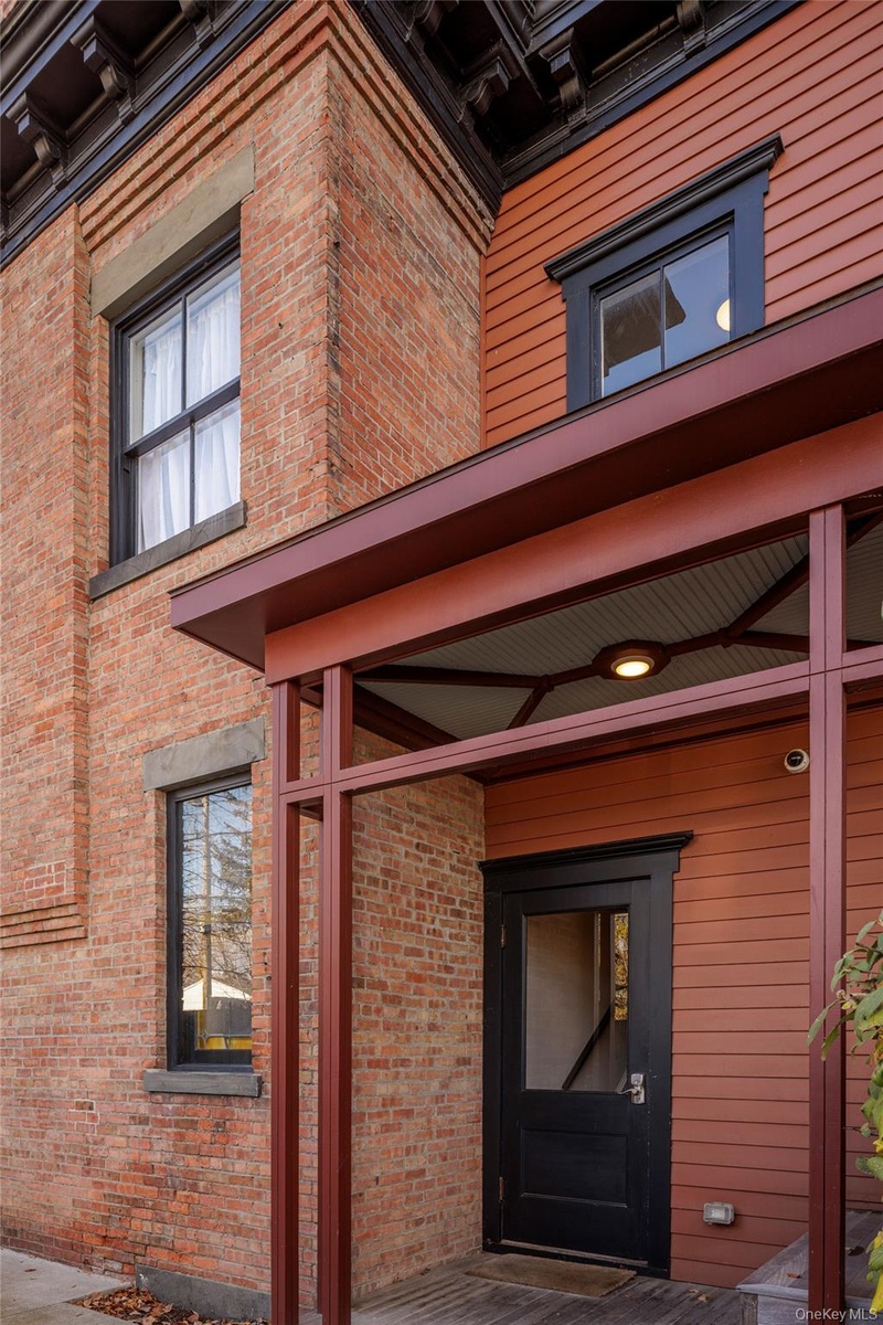 Doorway to property featuring brick siding