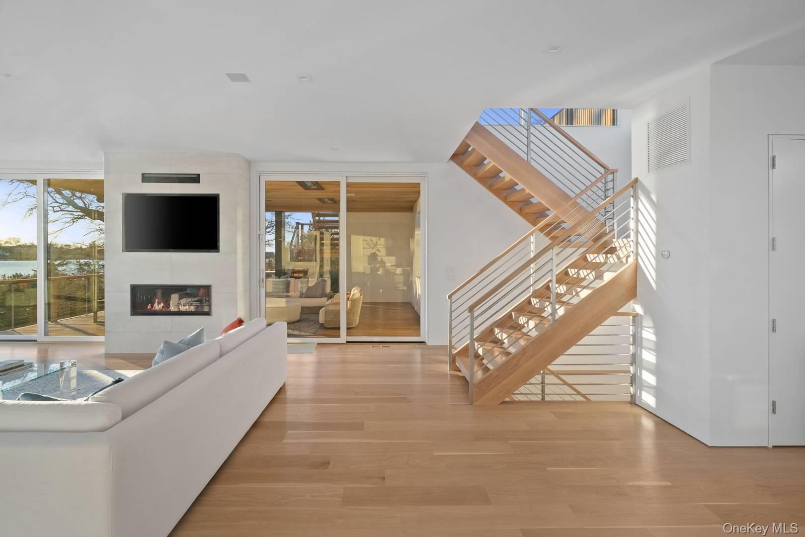 Living room featuring a fireplace, light hardwood / wood-style flooring, and a wall of windows