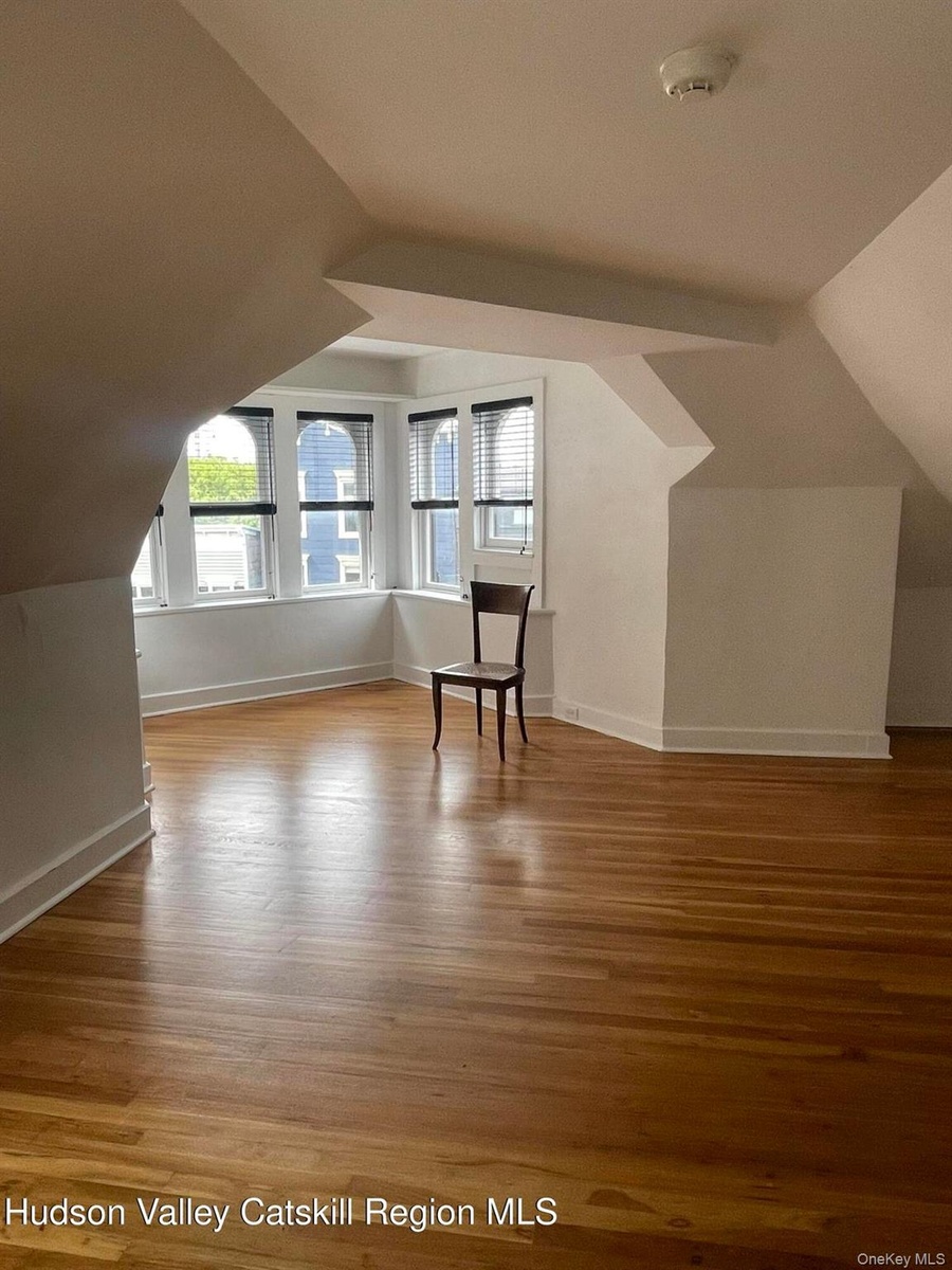 Additional living space with lofted ceiling and light wood-type flooring