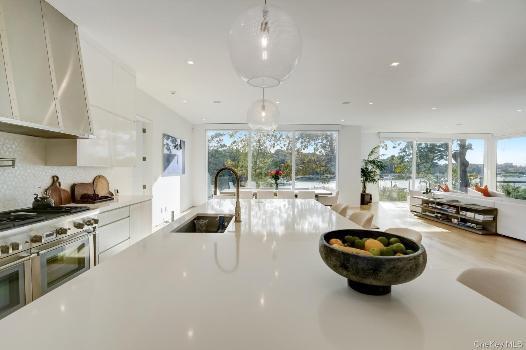 Kitchen with high end range, decorative light fixtures, plenty of natural light, and sink