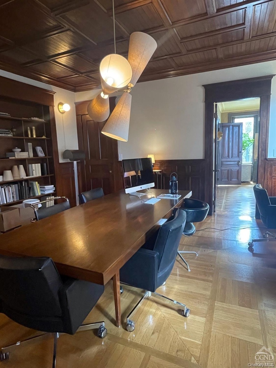 Home office with an ornate ceiling, a wainscoted wall, and wooden walls
