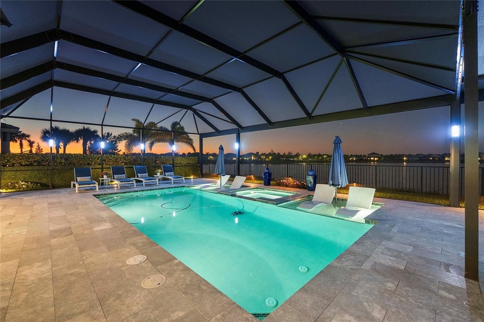 Twilight Photo Resort Style Pool with ambiant lighting and panoramic view of the lake