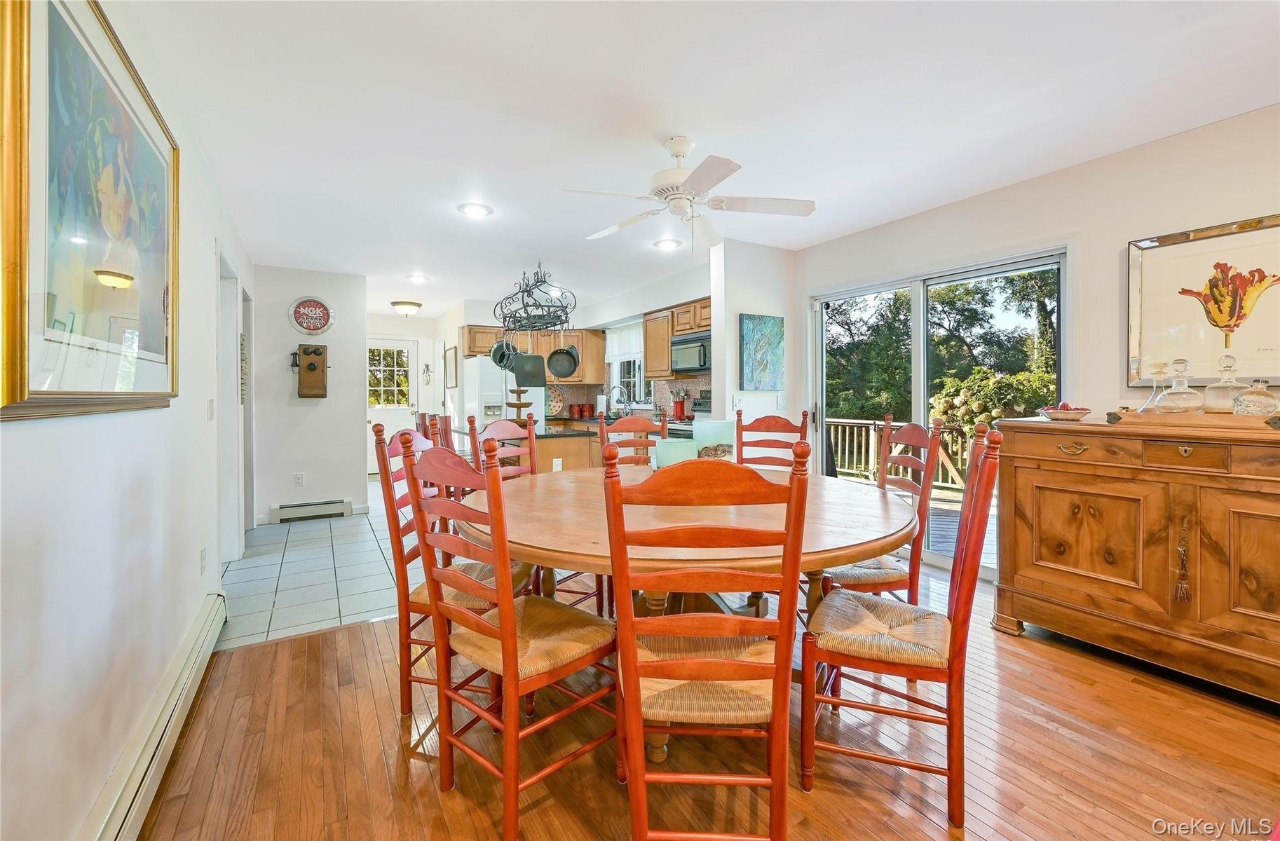 Dining space featuring a ceiling fan, light wood-style flooring, baseboard heating, and plenty of natural light