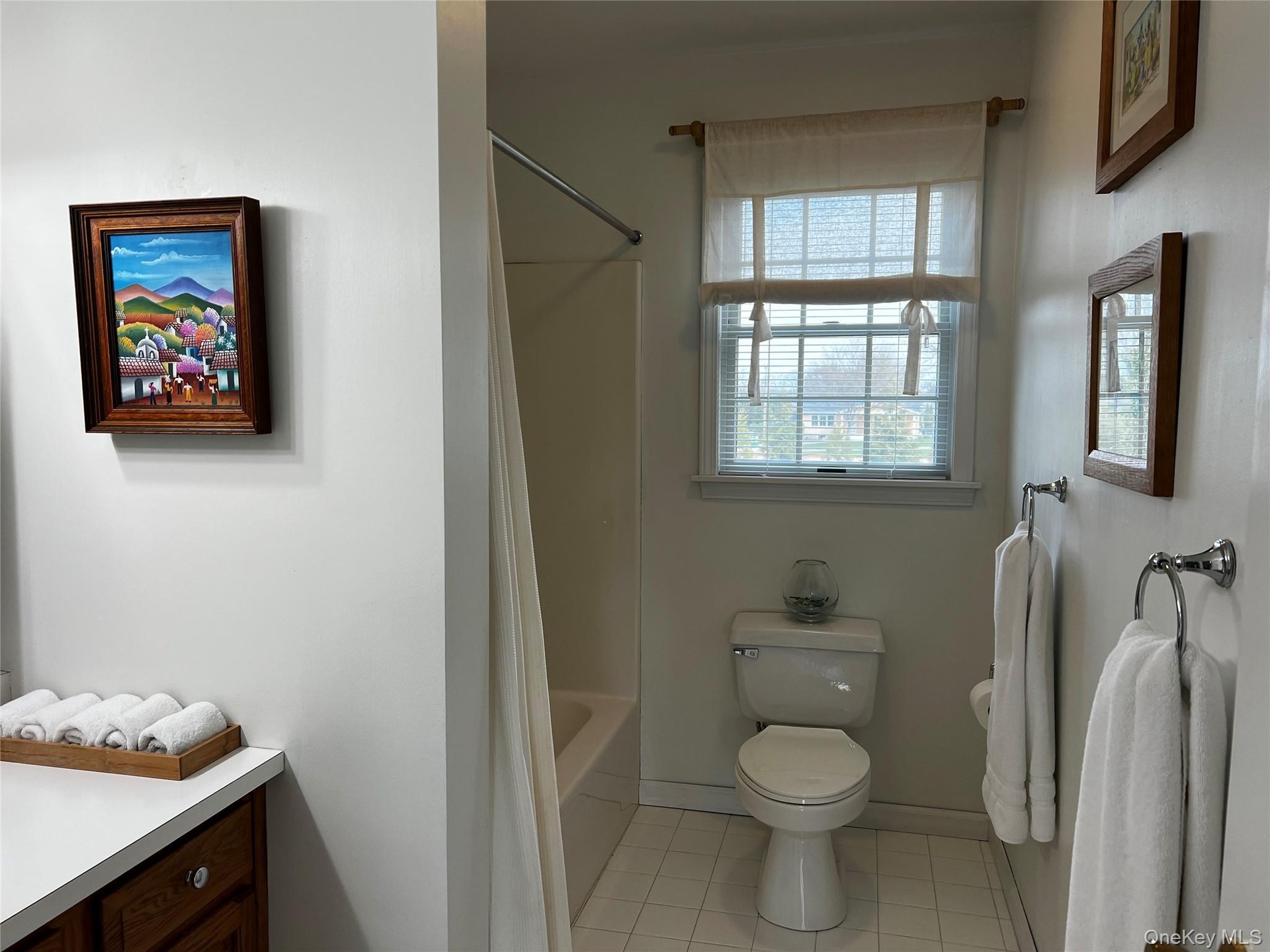 Bathroom with toilet, baseboards, shower / tub combo with curtain, tile patterned flooring, and vanity