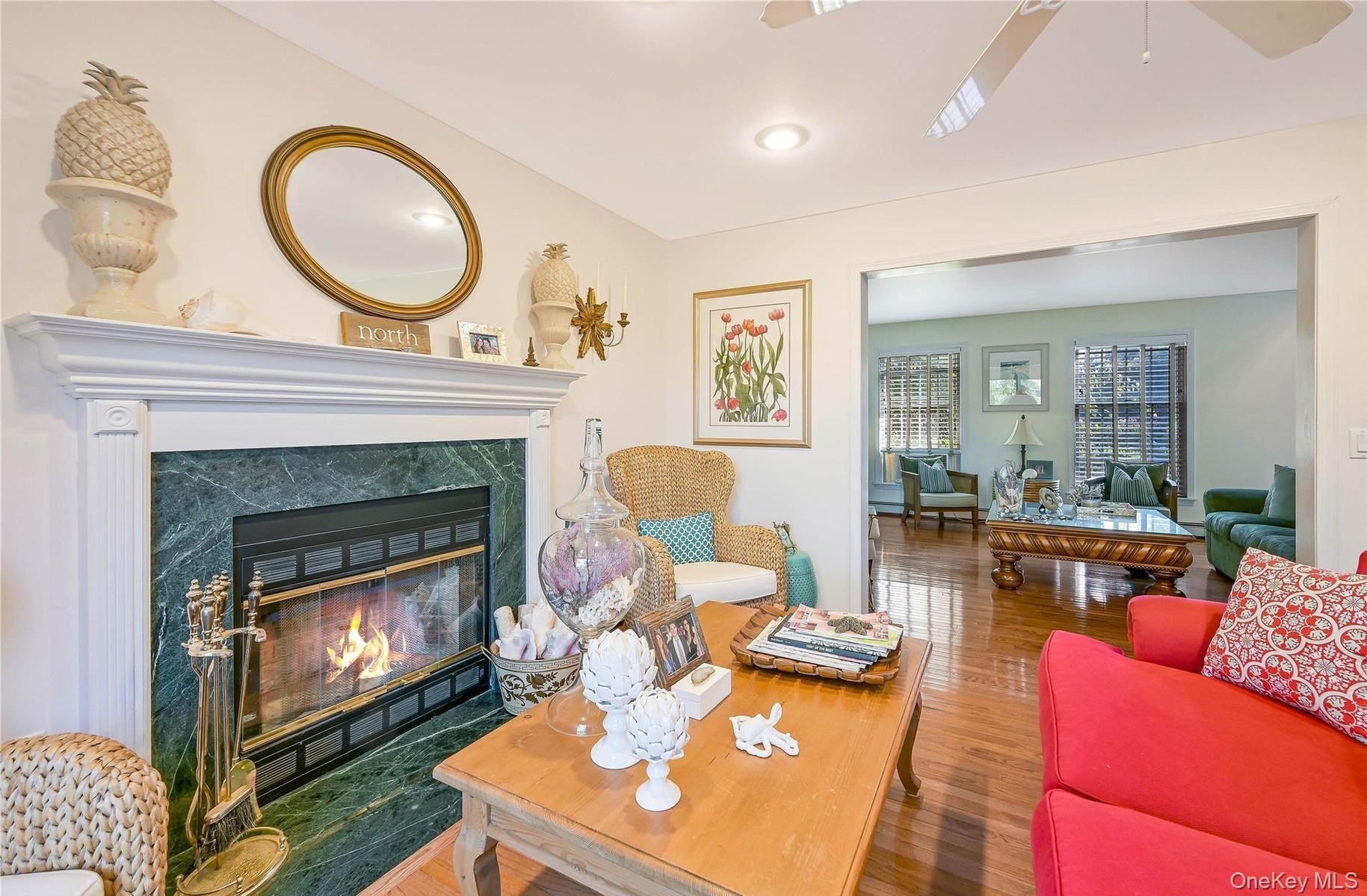 Living area featuring ceiling fan, a premium fireplace, and wood finished floors