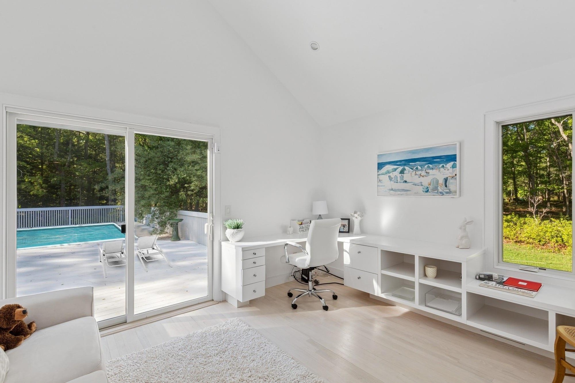 Office area featuring high vaulted ceiling and light wood-style flooring